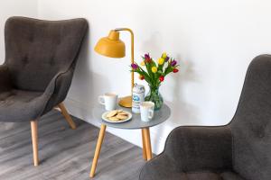a table with a vase of flowers and two chairs at The Nook - Self Serviced Accommodation in St Ives