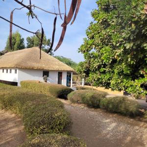 a hut with a thatched roof next to a road at la villa sur la plage in Palmarin