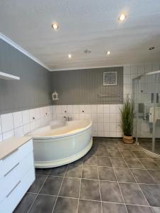 a large bathroom with a tub and a shower at Myranhaugen, house in Reine in Moskenes