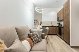 a living room with a couch and a kitchen at Suite Deluxe Valencia in Valencia