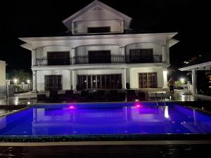 a large house with a large swimming pool at night at D'Offay Seaview Apartments in Beau Vallon