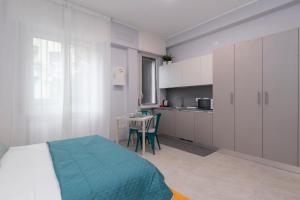a bedroom with a bed and a table and a kitchen at Montalbino place in Milan
