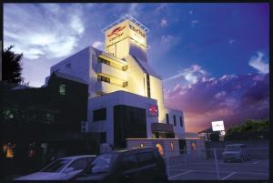 a building with a car parked in front of it at ホテル カーシュ Cache 男塾ホテルグループ in Himeji