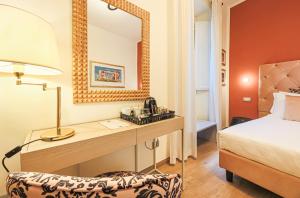 a bedroom with a desk with a bed and a mirror at Canto degli Aranci in Florence