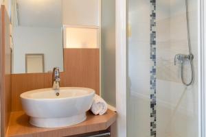 a bathroom with a sink and a shower at The Originals Access, Hôtel Millau Sud in LʼHospitalet-du-Larzac +33 photos