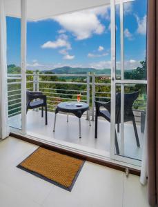 Un balcón con 2 sillas y una mesa con vistas. en Regent Heights, en Kandy