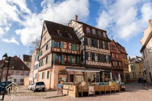 um edifício alto com uma loja em frente em Au Bonheur des Anges Appartement 2 chambres avec terrasse em Colmar