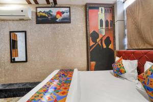 a bedroom with a bed and paintings on the wall at FabExpress P2 in Bhopal