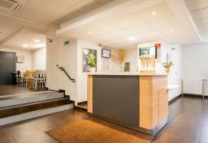 a lobby with a bar in the middle of a room at B&B HOTEL Valenciennes Sud in Valenciennes
