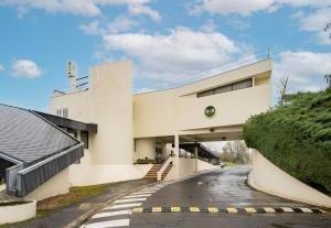 un edificio blanco con una carretera delante de él en B&B HOTEL Valenciennes Sud, en Valenciennes