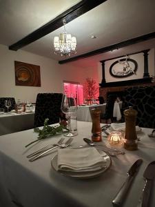 a dining room table with a white tablecloth and silverware at Scole Inn Hotel in Diss