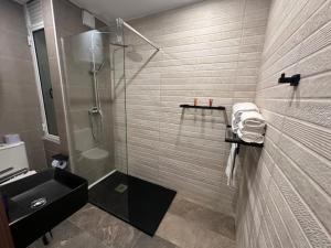 a bathroom with a shower and a sink at La Bella Guesthouse in St. Julianʼs