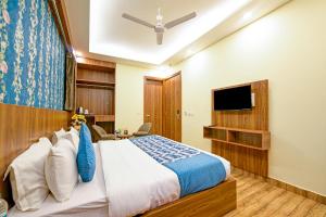 a bedroom with a bed and a flat screen tv at Presedent Airport Hotel Near Delhi International Airport in New Delhi