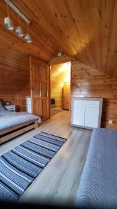 - une chambre avec un lit et un tapis dans l'établissement Sajzy Ostoja - domek nad jeziorem, à Sajzy