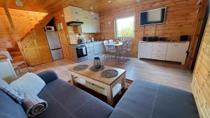 uma sala de estar com um sofá e uma mesa numa cabina em Sajzy Ostoja - domek nad jeziorem em Sajzy