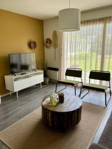 een woonkamer met een salontafel en een televisie bij Appartement De Kompaan, Resort Amelander Kaap in Hollum