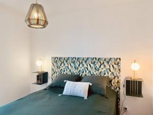 una camera con un letto verde e due lampade di BEL'ORIZONTE Proche centre ville et plage, vue mer a Propriano