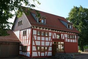 una casa roja y blanca con techo de gambrel en Deutsches Haus Hotel Restaurant Gastwirtschaft Biergarten am Radweg Bermuthshain, en Bermuthshain