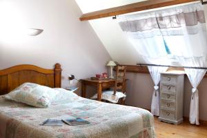 a bedroom with a bed and a dresser and a window at Domaine Le Puits De Jeanne in Plouégat-Moysan