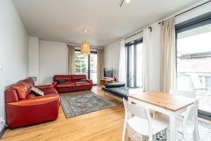 a living room with a red couch and a table at RentPlanet - Kamienica Retmana in Krakow