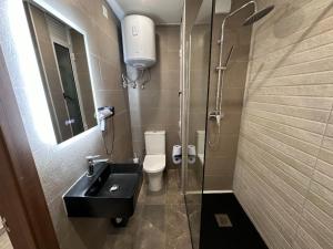 a bathroom with a sink and a toilet and a shower at La Bella Guesthouse in St. Julianʼs
