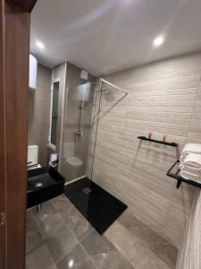 a bathroom with a shower and a sink at La Bella Guesthouse in St. Julianʼs