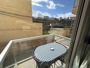 una mesa en un balcón con vistas a la ciudad en La Bella Guesthouse, en San Julián