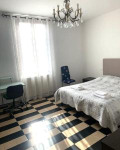 ブレシアにあるCASA VACANZA FERRARI2のベッドルーム1室(ベッド1台、デスク、シャンデリア付)