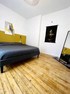 een slaapkamer met een bed en een houten vloer bij Cocon en centre-ville in Épernay