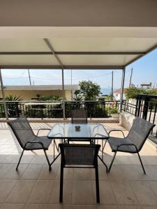 a patio with a table and chairs on a roof at PanDora Home in Moúdhros
