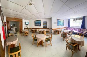 - une salle à manger avec des tables, des chaises et un canapé dans l'établissement Hotel El Pescador, à Sant Pere Pescador