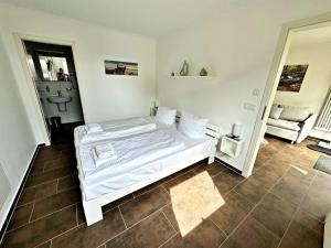 - une chambre avec un lit blanc et une chaise dans l'établissement Ferienwohnung Altenberg 02, à Ahlbeck