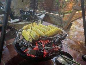a grill with a bunch of corn on it at Nhà gỗ Homestay in Bao Loc