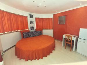 a bedroom with a bed and a desk in a room at Dardanos Pension in Hamidiye