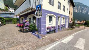 un edificio púrpura con flores a un lado en Apartments Giovannini en Fai della Paganella