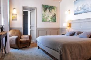 a bedroom with a large bed and a chair at La Martinoise Patio in Saint-Martin-de-Ré
