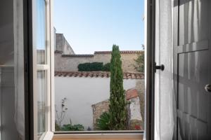 an open window with a view of a building at La Martinoise Patio in Saint-Martin-de-Ré