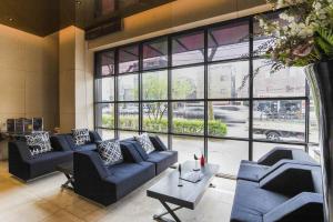 a living room with blue couches and a large window at Sota stay Hotel in Seoul