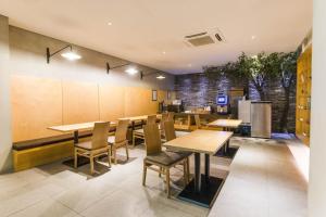 une salle à manger avec des tables et des chaises en bois dans l'établissement Sota stay Hotel, à Séoul