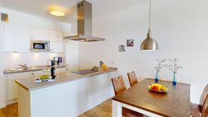 a kitchen and dining room with a wooden table and a counter at Südkap G-06 in Pelzerhaken