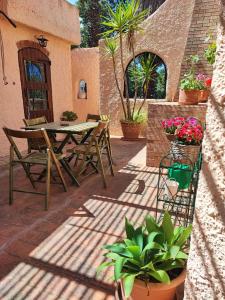 a patio with a table and chairs and potted plants at Casetta in campagna di Marilou (Iun R5361) in Maracalagonis