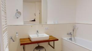 a bathroom with a sink and a mirror and a tub at Südkap G-06 in Pelzerhaken +34 photos