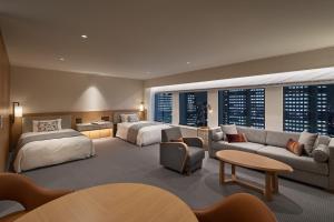 a hotel room with two beds and a couch at Keio Plaza Hotel Tokyo in Tokyo