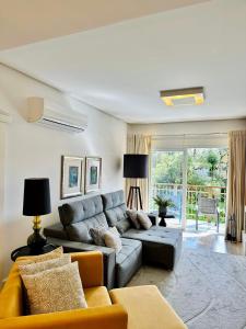 a living room with a gray couch and a yellow sofa at Apto LINDO com lareira, piscina aquecida e jacuzzi in Gramado