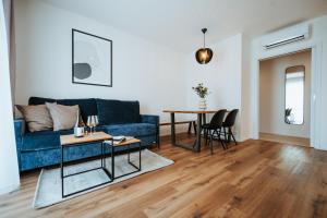 a living room with a blue couch and a table at Apartmány Dog in Dock in Veselí nad Moravou