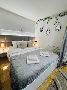 - une chambre avec un grand lit et 2 serviettes dans l'établissement Apartment Irma, à Sarajevo