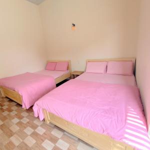 胡志明市的住宿－Mây Phú Quý，配有粉红色床单的客房内的两张床