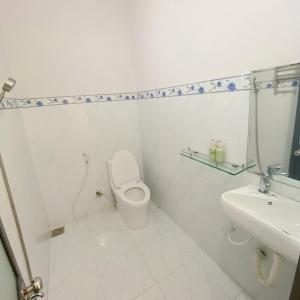 ein weißes Bad mit einem WC und einem Waschbecken in der Unterkunft Mây Phú Quý in Ho-Chi-Minh-Stadt
