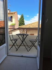 einen Balkon mit einem Tisch mit zwei Weingläsern darauf in der Unterkunft 2 pièces avec terrasse à 5 minutes de la plage in Saint-Laurent-du-Var