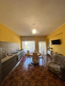 un soggiorno con tavolo e cucina di La Soffitta - Appartamenti in Villa a San Giorgio a Liri